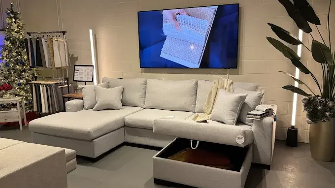 Toronto SIXTREND showroom interior with a Zen sofa with chaise, fabric sample display, and Christmas tree
