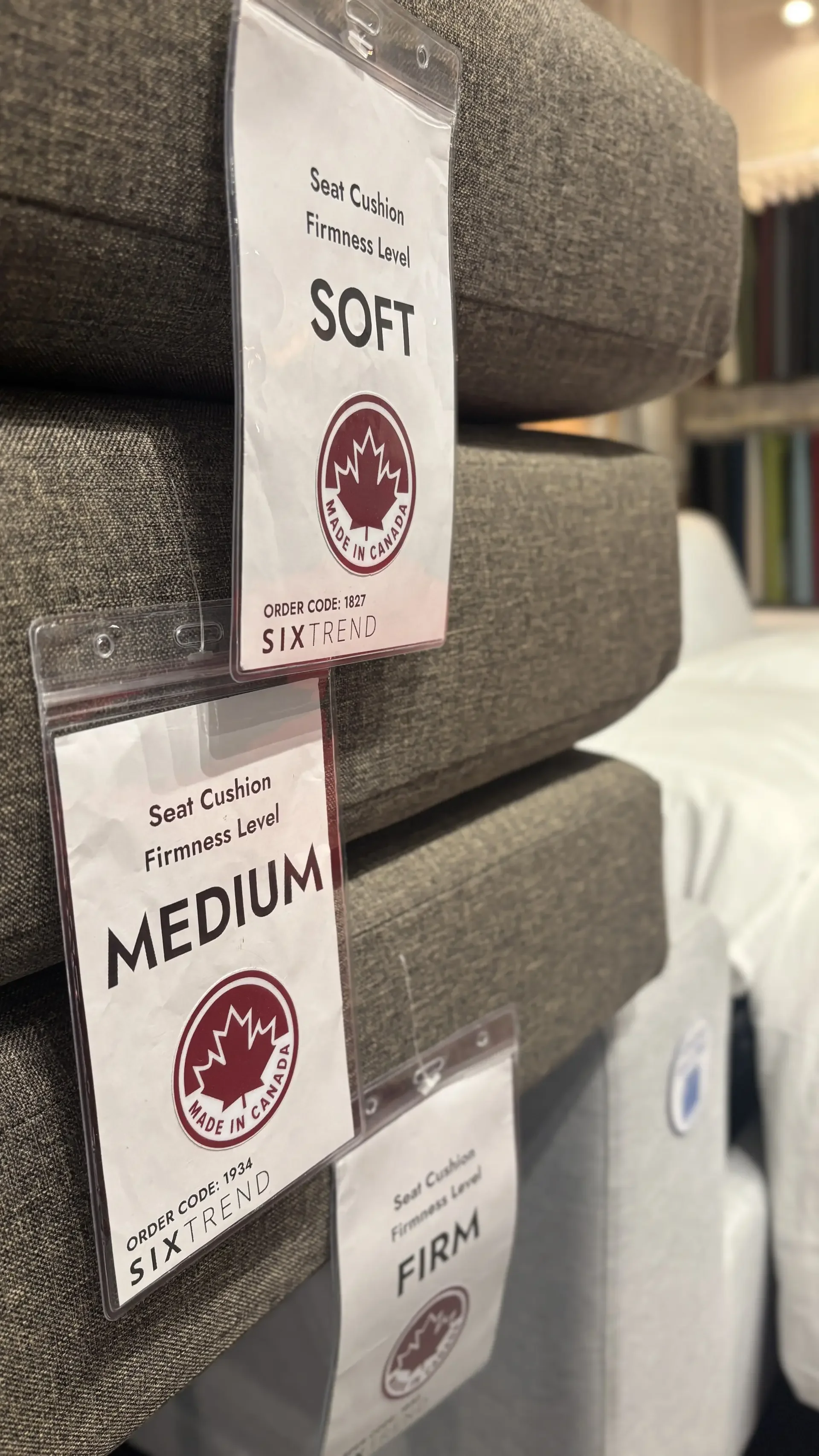 SIXTREND seat-cushion firmness sample tags — Soft, Medium, and Firm — clipped to folded cushion stacks in the Toronto showroom