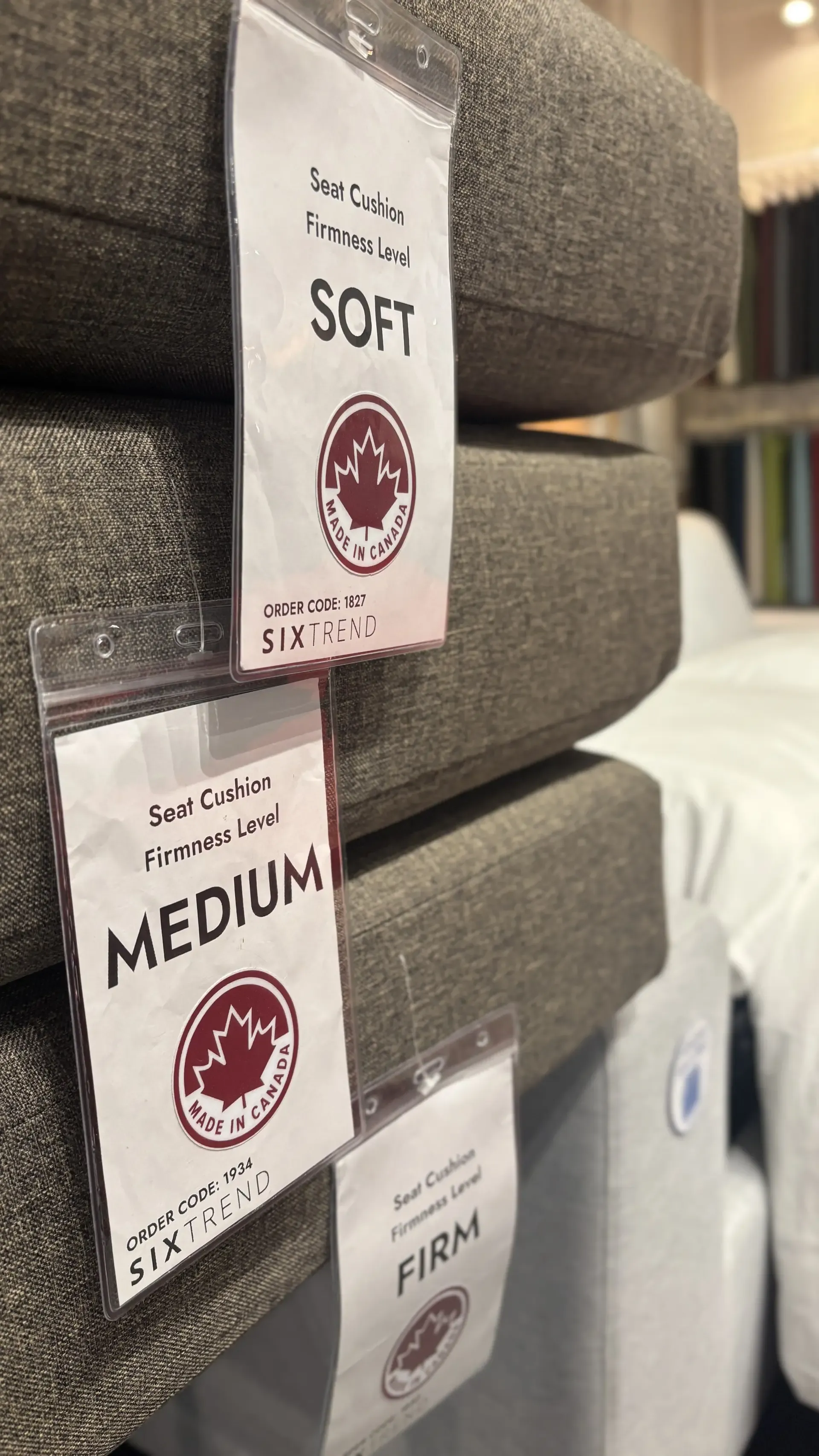 SIXTREND seat-cushion firmness sample tags — Soft, Medium, and Firm — clipped to folded cushion stacks in the Toronto showroom