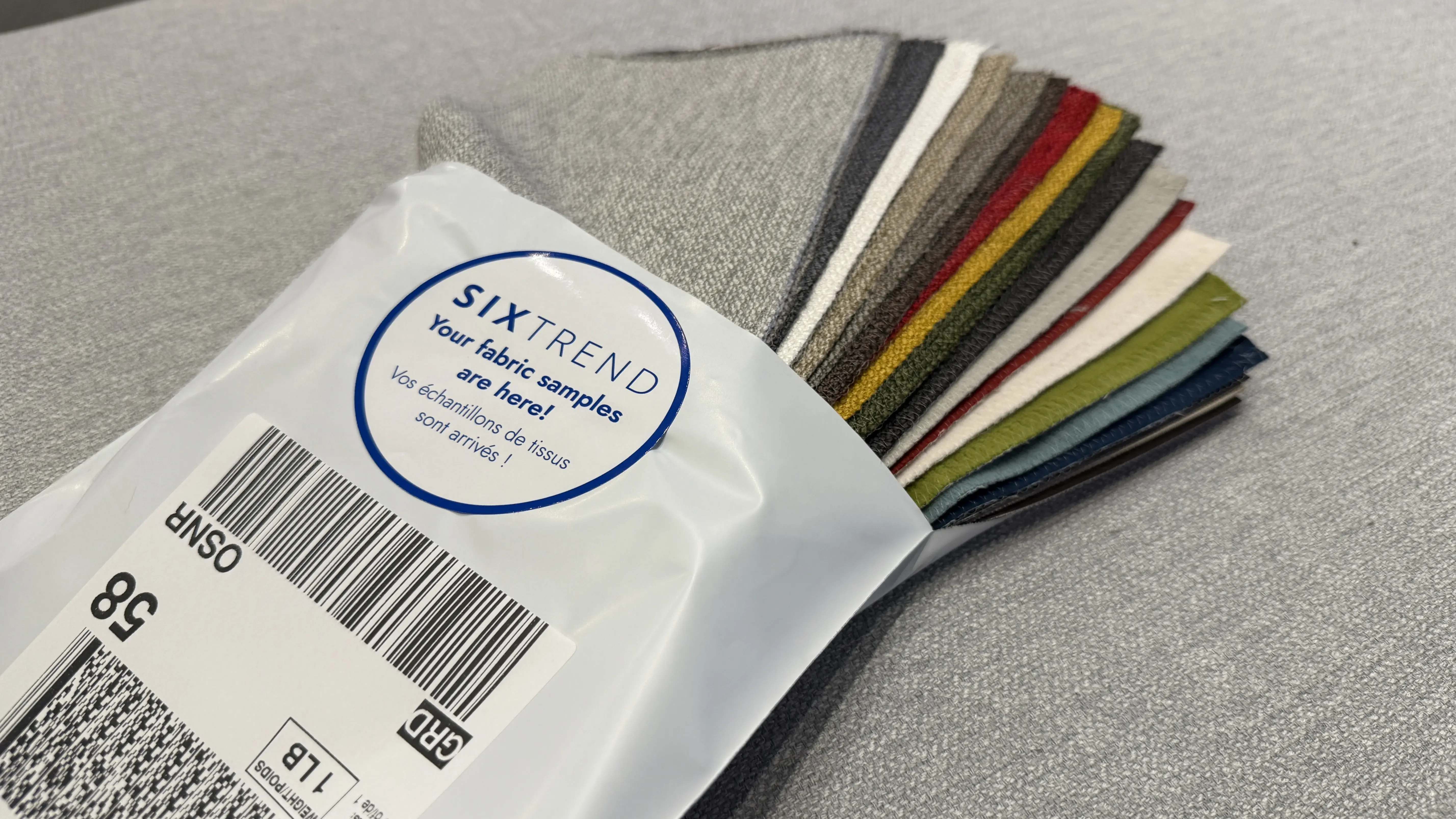 SIXTREND fabric sample kit with assorted upholstery swatches — greys, navy, red, mustard, olive — in a labelled clear envelope
