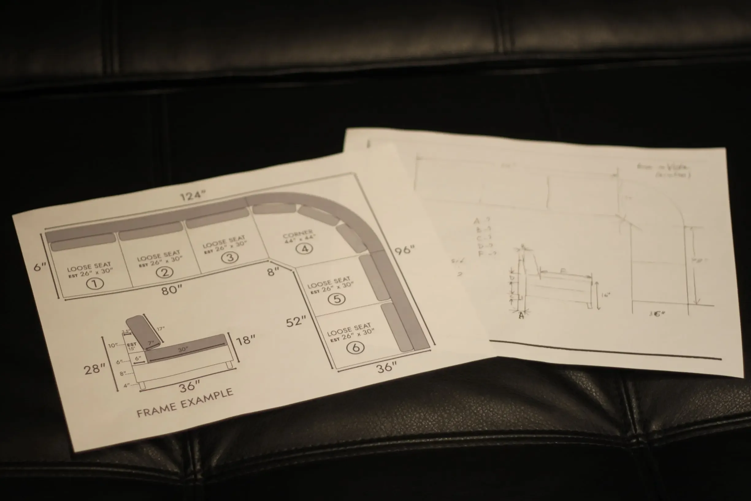 Hand-drawn sectional sofa layout sketches with detailed measurements and a side-view frame example on a black leather background.
