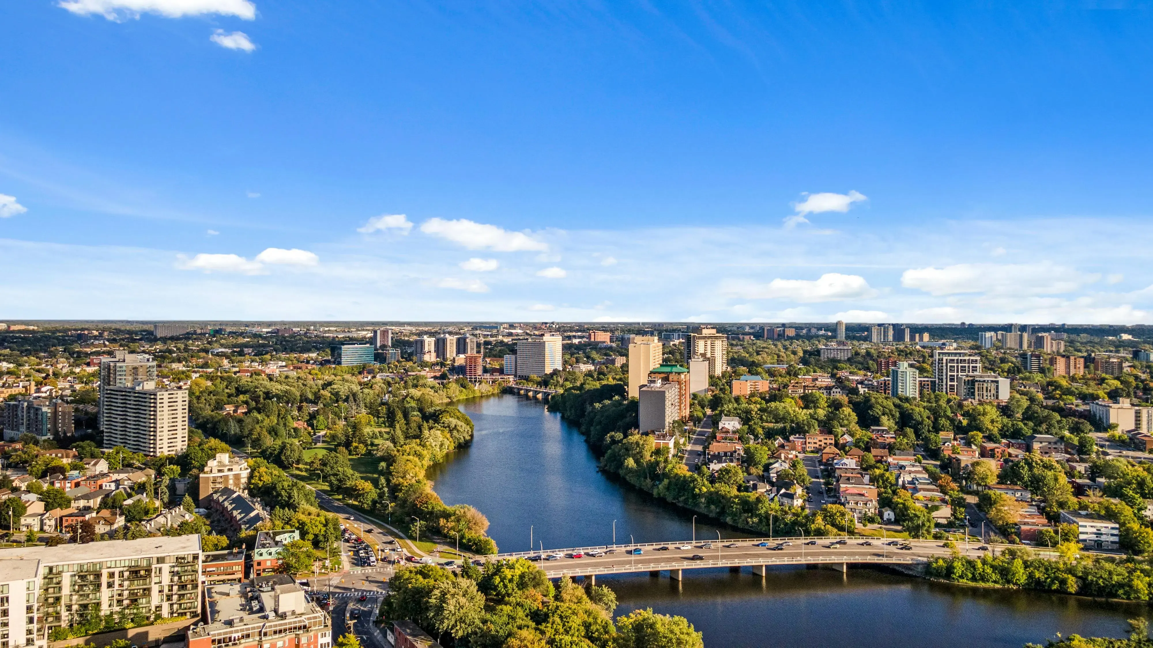 Aerial view of a Canadian city with river, bridge, and residential neighbourhoods
